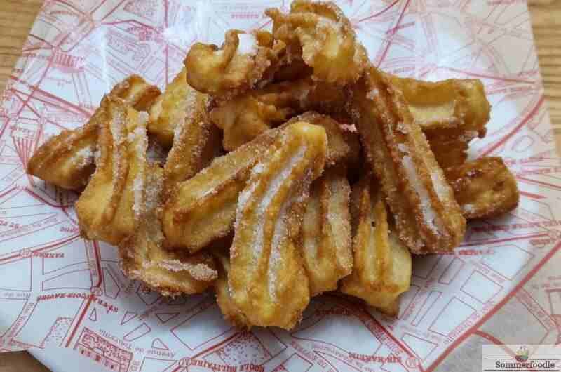Petits churros sur papier rouge et blanc paraffiné.