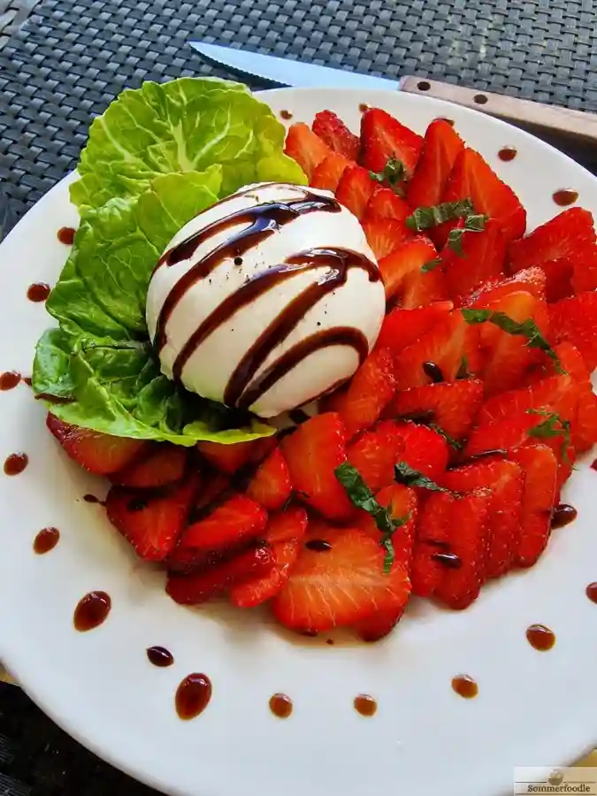 Carpaccio de fraises et burrata, filet de crème balsamique.